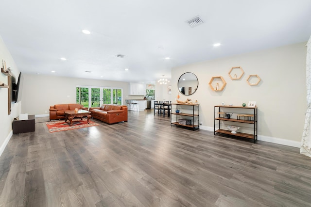 living area with baseboards, visible vents, wood finished floors, and recessed lighting