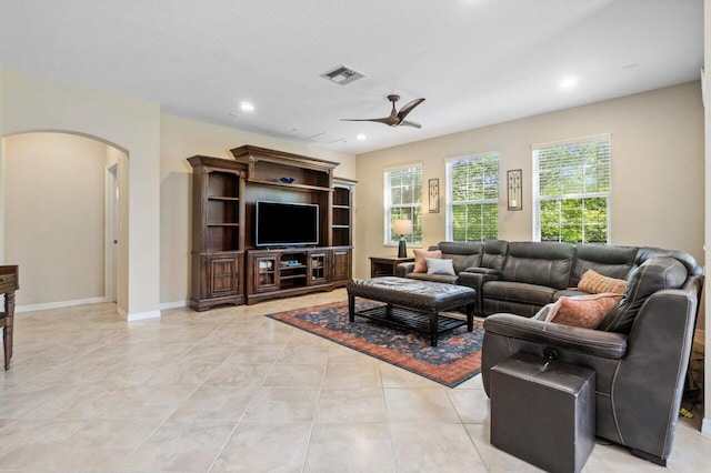 living area with light tile patterned floors, visible vents, arched walkways, a ceiling fan, and recessed lighting