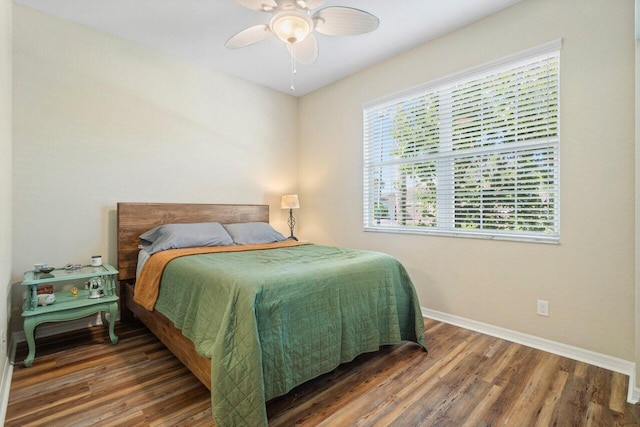 bedroom with ceiling fan, baseboards, and wood finished floors