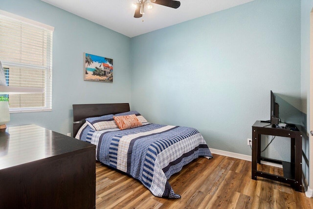 bedroom featuring ceiling fan, baseboards, and wood finished floors