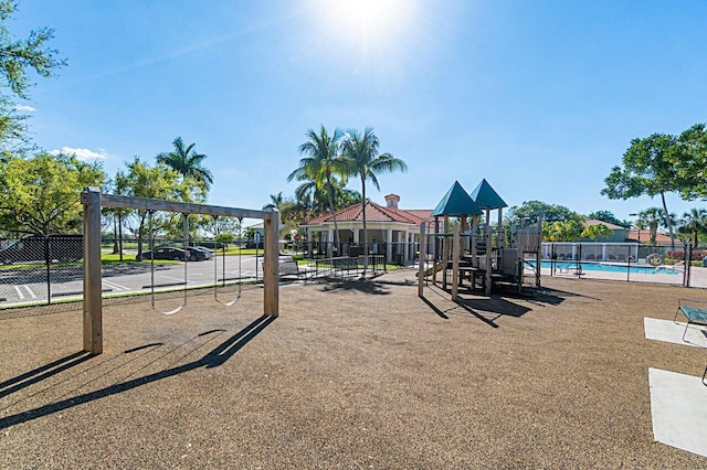 communal playground featuring fence and a community pool