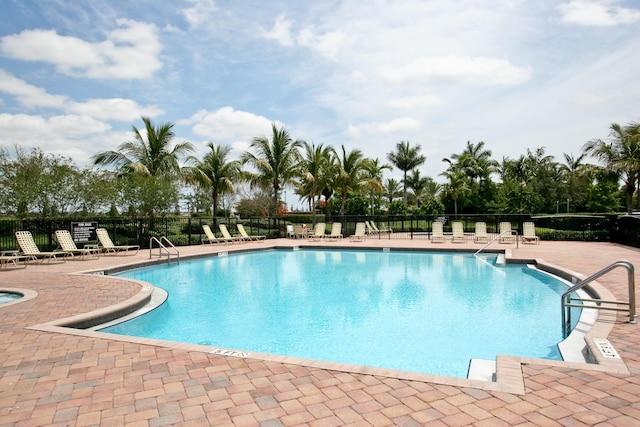 community pool with fence and a patio