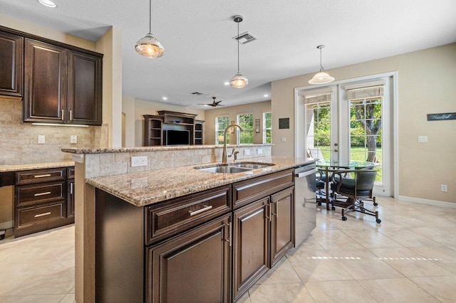 kitchen with visible vents, hanging light fixtures, backsplash, stainless steel dishwasher, and a sink