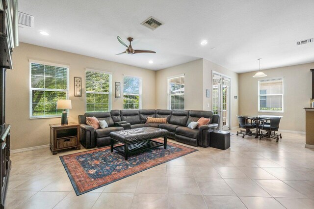 living area with light tile patterned floors, baseboards, and visible vents