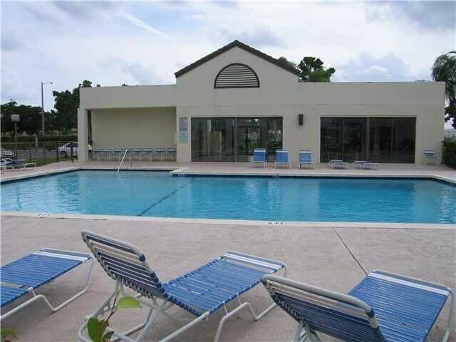 community pool with a patio area and fence