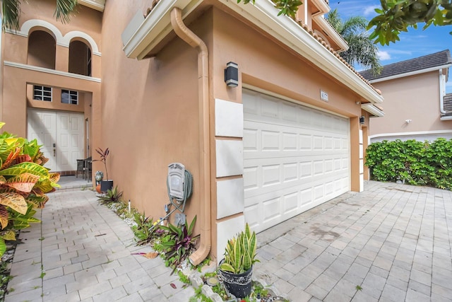 garage with decorative driveway