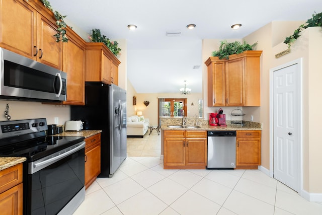 kitchen with a sink, appliances with stainless steel finishes, a peninsula, and brown cabinetry