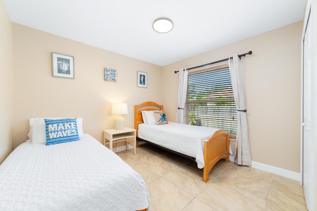 bedroom featuring light tile patterned floors and baseboards