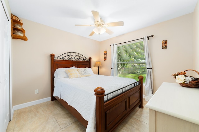 bedroom with light tile patterned floors, baseboards, and ceiling fan