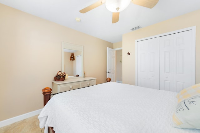 bedroom with visible vents, baseboards, ceiling fan, light tile patterned floors, and a closet