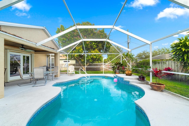 view of swimming pool featuring glass enclosure, a patio area, a fenced backyard, and a fenced in pool