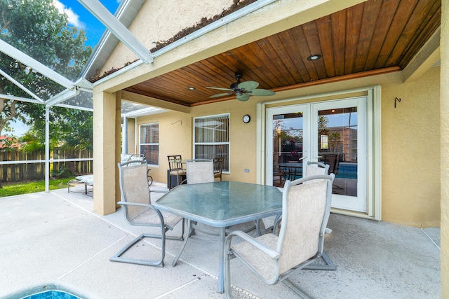 view of patio / terrace with outdoor dining space, ceiling fan, fence, french doors, and a lanai