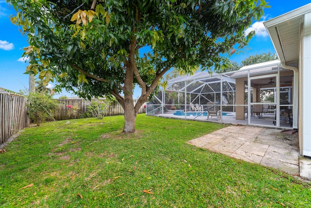 view of yard with a patio area, glass enclosure, a fenced backyard, and a fenced in pool