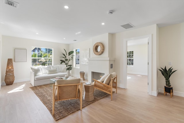 living room with light wood-style flooring, baseboards, and recessed lighting