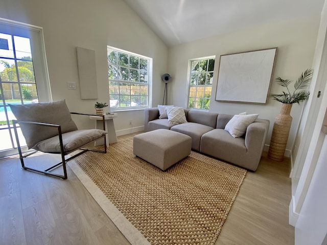 sitting room featuring light wood finished floors, lofted ceiling, and baseboards