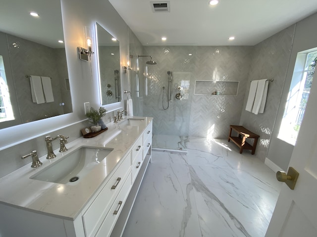 full bathroom with a sink, visible vents, double vanity, and a walk in shower