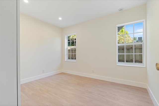 unfurnished room with light wood finished floors, plenty of natural light, recessed lighting, and baseboards