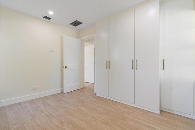unfurnished bedroom featuring light wood-type flooring, baseboards, and recessed lighting