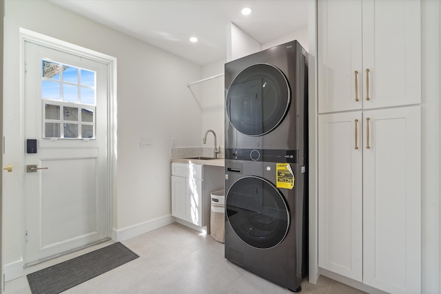 laundry area with stacked washing machine and dryer, cabinet space, baseboards, and recessed lighting