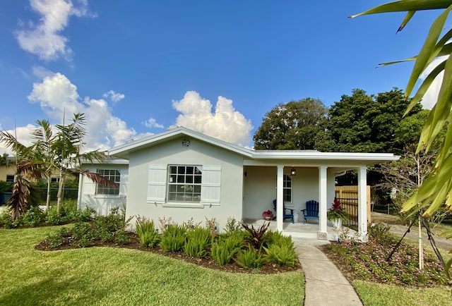 108 NW 4th Ave, Delray Beach, FL 33444 - view of front facade featuring covered porch, a front lawn, and stucco siding