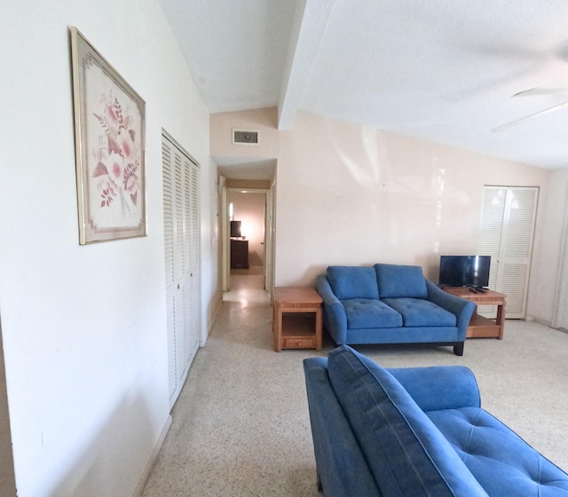 living area with vaulted ceiling with beams, ceiling fan, speckled floor, and visible vents