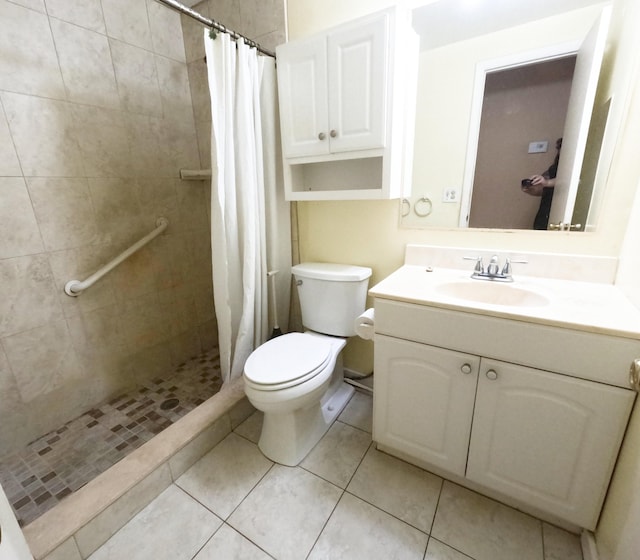 bathroom featuring toilet, tile patterned floors, a shower stall, and vanity