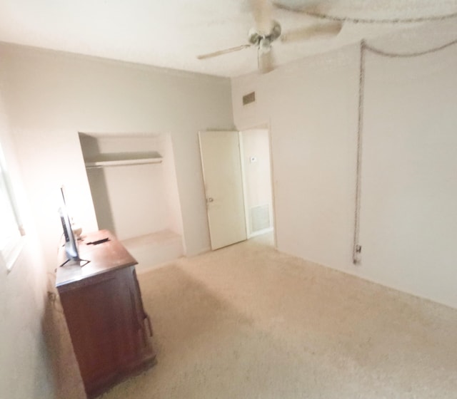 carpeted bedroom featuring a closet, visible vents, and ceiling fan