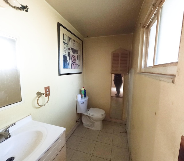 half bath featuring vanity, toilet, and tile patterned floors