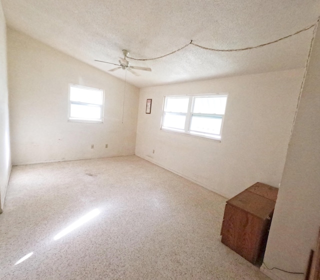 empty room featuring ceiling fan, a textured ceiling, and speckled floor