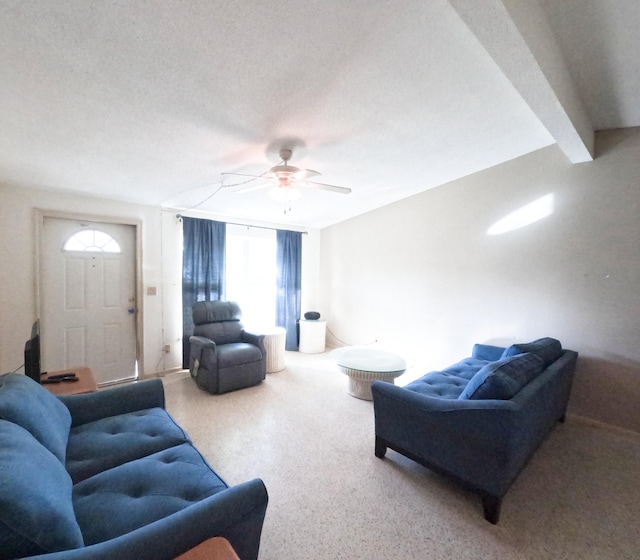 living area featuring a textured ceiling, ceiling fan, and lofted ceiling with beams