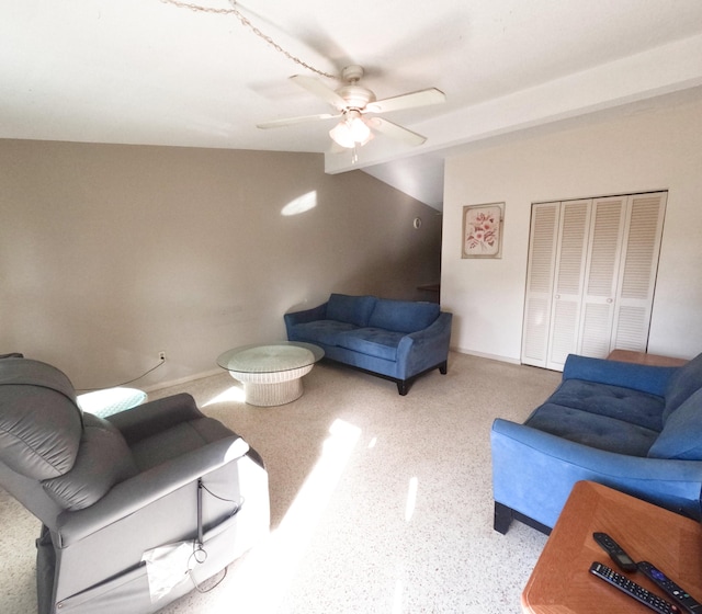 living room featuring ceiling fan, vaulted ceiling, baseboards, and speckled floor