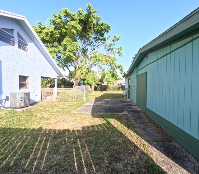 view of yard with a patio, fence, and central air condition unit