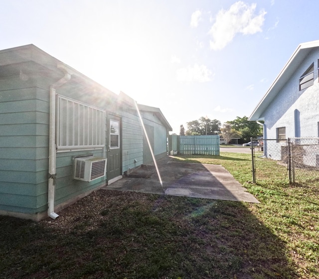 view of yard with a patio area, fence, and a wall mounted AC