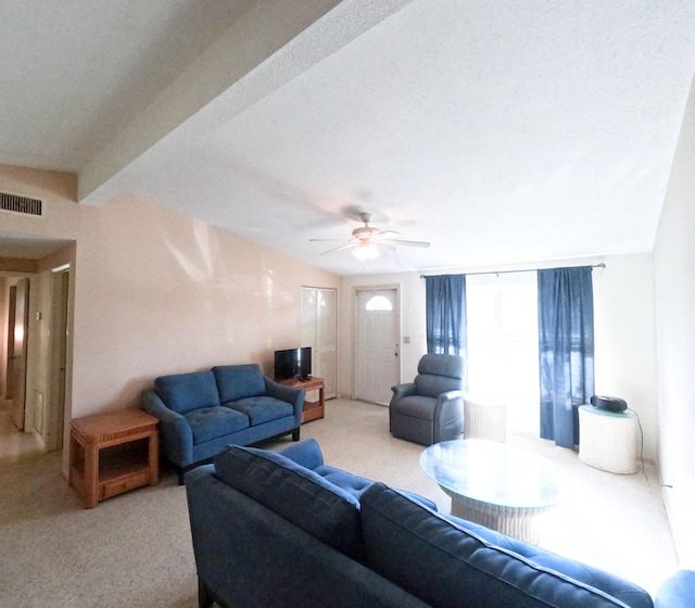 living area featuring visible vents, ceiling fan, light carpet, and lofted ceiling with beams