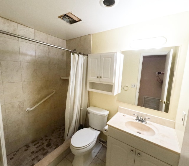 bathroom featuring vanity, a tile shower, toilet, and tile patterned floors