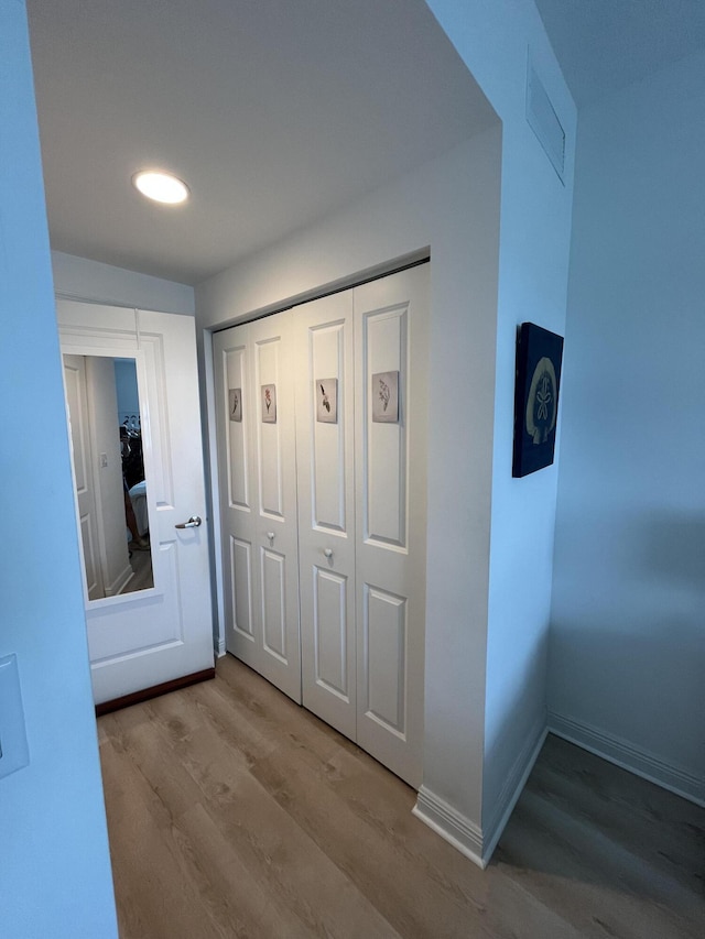 hallway with recessed lighting, wood finished floors, visible vents, and baseboards