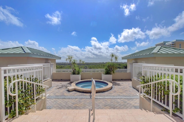 view of swimming pool with a patio area, fence, and an in ground hot tub