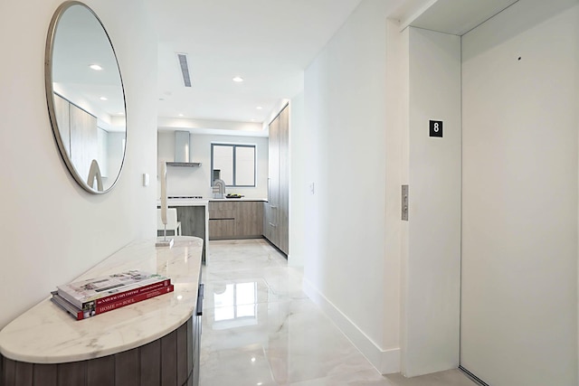 hall featuring visible vents, a sink, recessed lighting, elevator, and baseboards