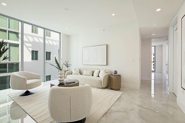 living area featuring recessed lighting, baseboards, marble finish floor, and expansive windows