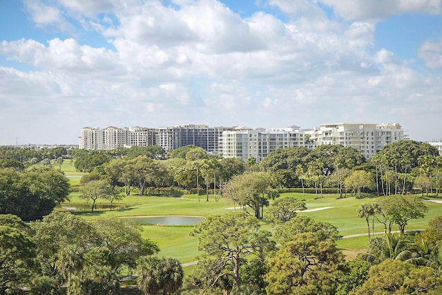 view of home's community featuring view of golf course, a lawn, and a water view