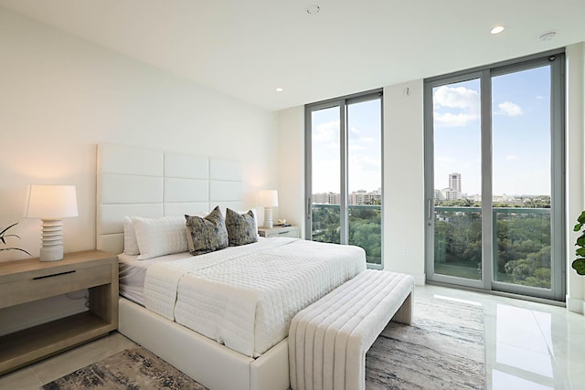 bedroom featuring a wall of windows, a view of city, access to exterior, and recessed lighting