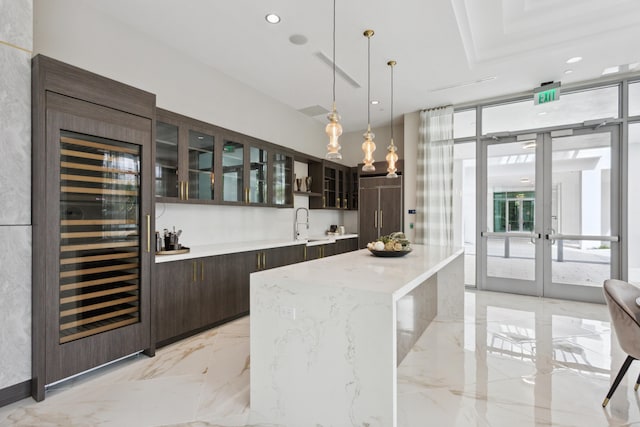 bar with wine cooler, pendant lighting, expansive windows, paneled built in fridge, and marble finish floor