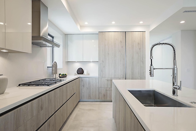 kitchen featuring range hood, white cabinetry, modern cabinets, and a sink