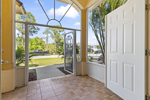 entryway featuring brick floor and a sunroom