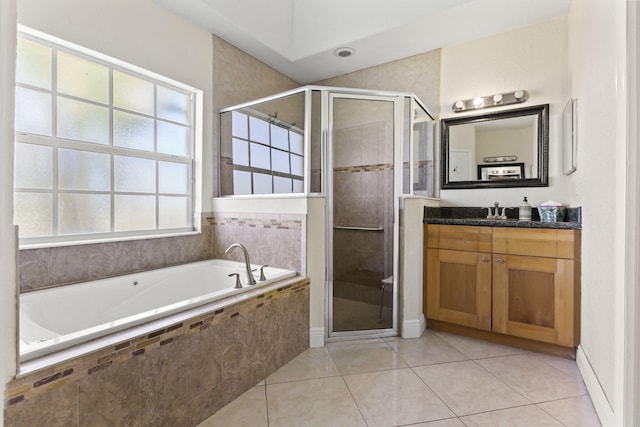 full bath featuring a stall shower, tile patterned flooring, a garden tub, and vanity