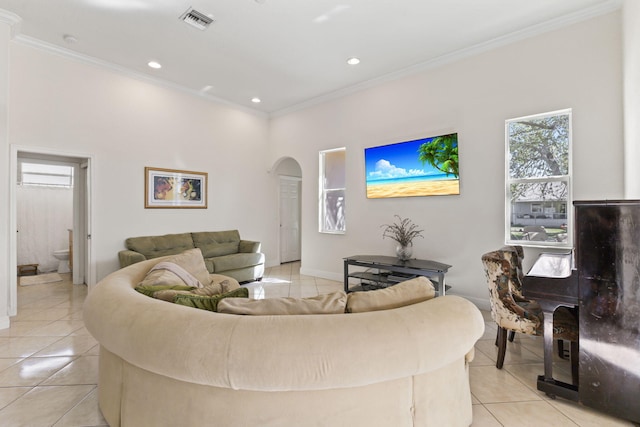 living room featuring ornamental molding, arched walkways, visible vents, and light tile patterned floors