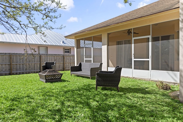 view of yard with an outdoor fire pit, a sunroom, and fence