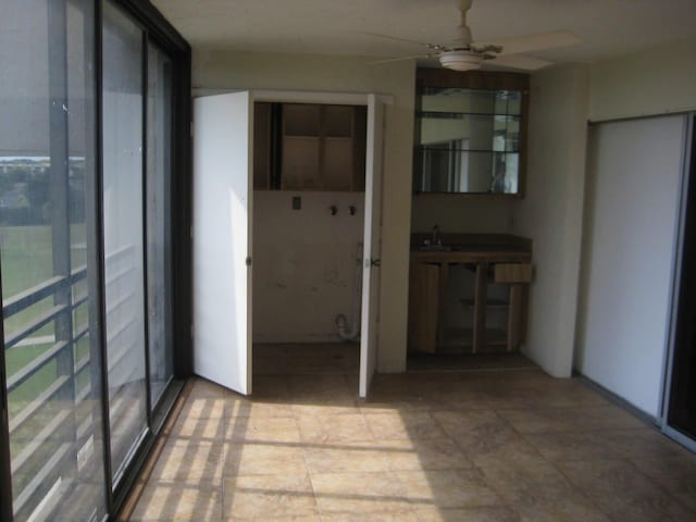 interior space with a ceiling fan and a sink