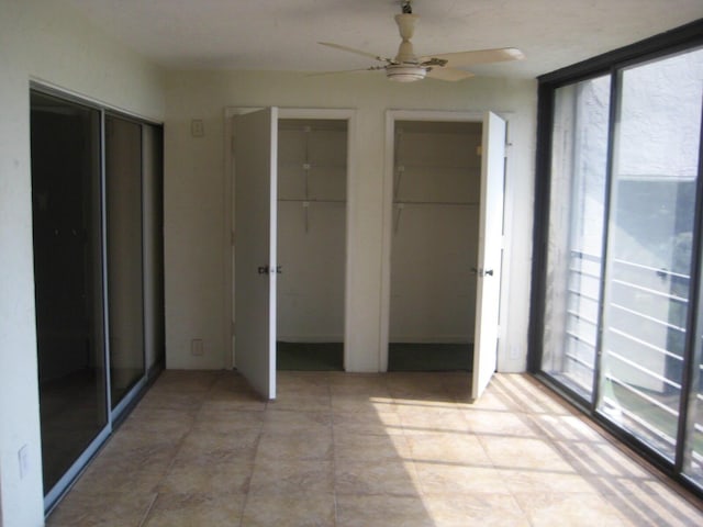 interior space featuring two closets and ceiling fan