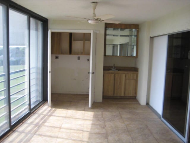 interior space with a ceiling fan and a sink